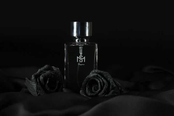 a bottle of perfume sitting on top of a bed